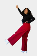 Aisha wearing the Dolores Pantacourt in red. Cotton twill wide-legged pants with elastic waistband and invisible zipper, with pockets and belt rings. 100% Brazilian grown BCI cotton. Ethically produced in downtown São Paulo, Brazil