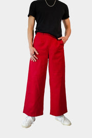 Close up of Trivan wearing the Dolores Pantacourt in red. Cotton twill wide-legged pants with elastic waistband and invisible zipper, with pockets and belt rings. 100% Brazilian grown BCI cotton. Ethically produced in downtown São Paulo, Brazil